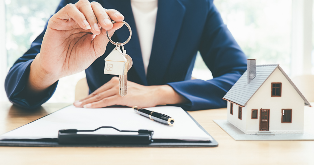 true agent holding keys with a small house